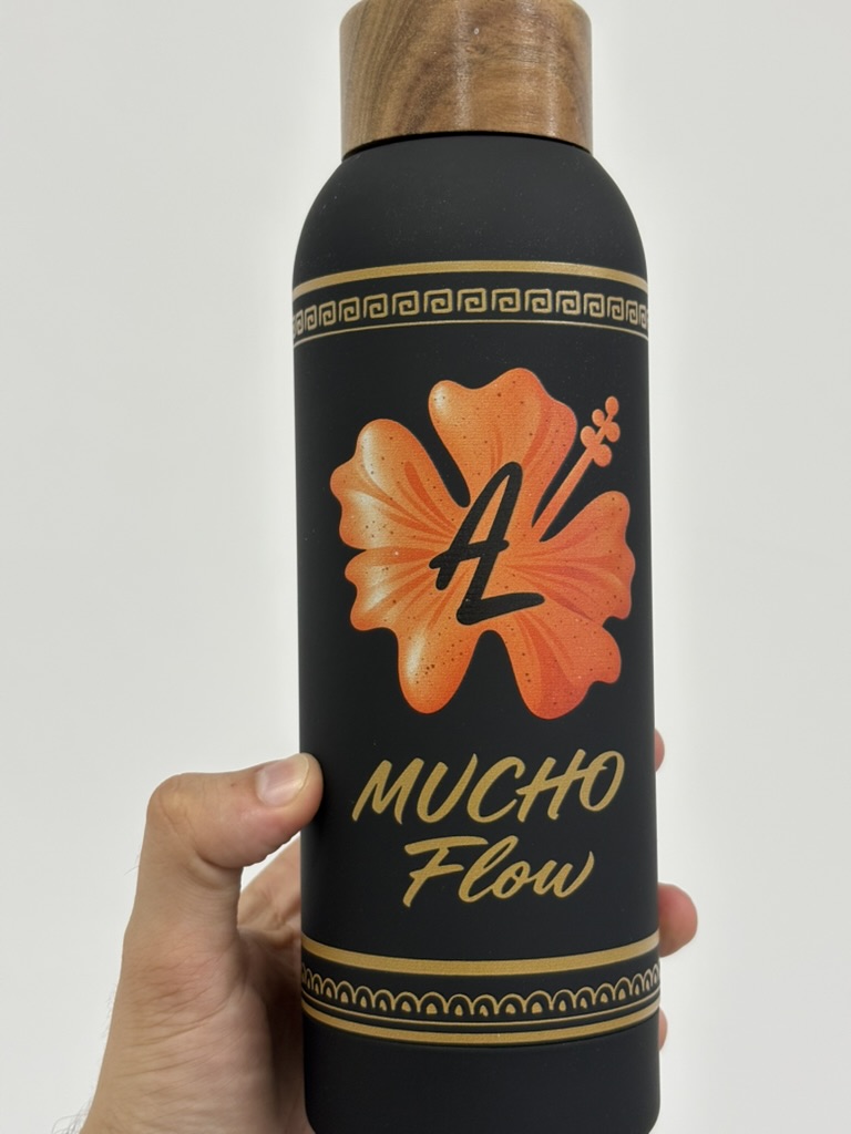 Detalle del diseño floral naranja y dorado en el bidón Cosmix negro