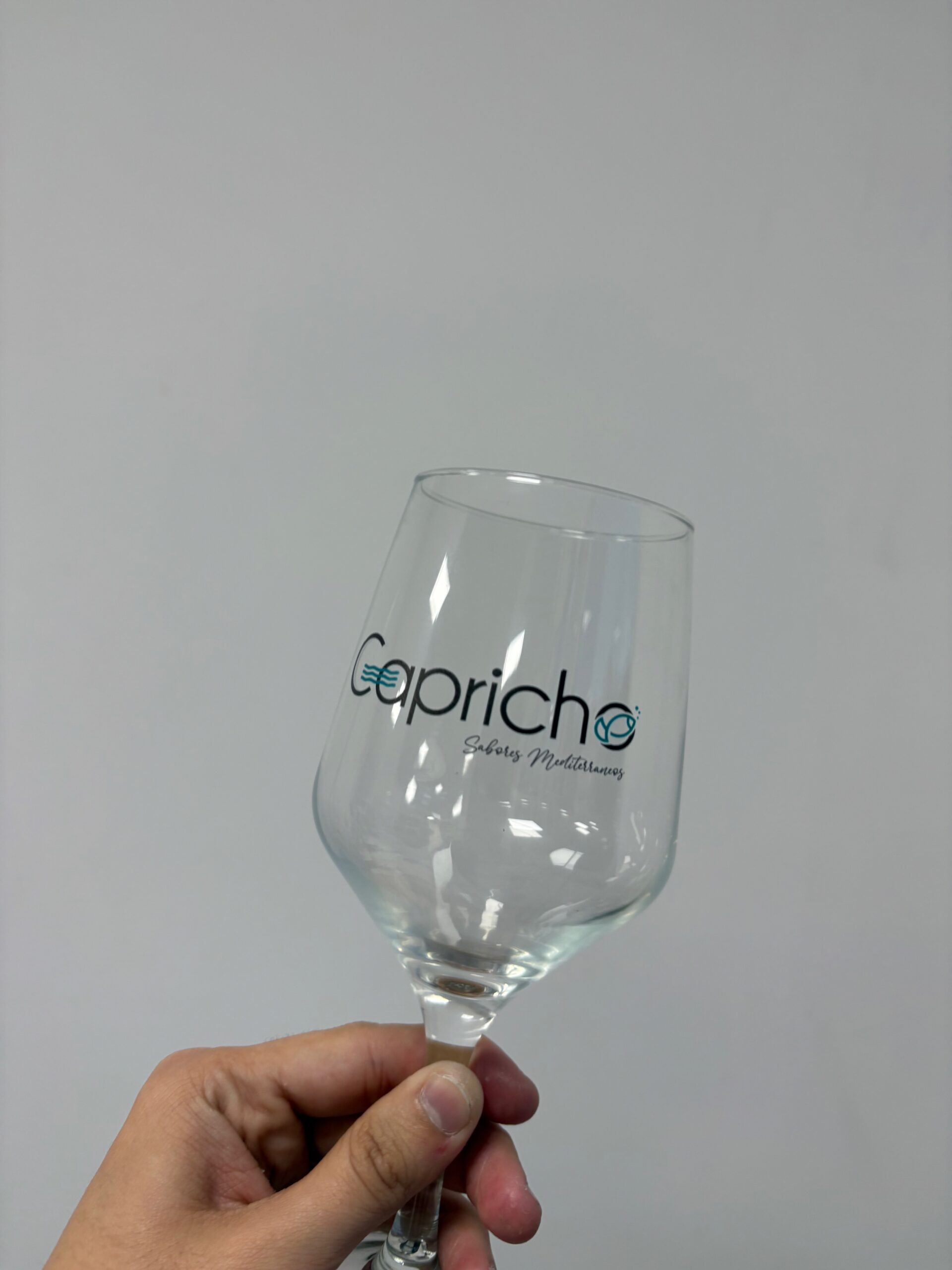 Copa de cristal personalizada con el logotipo Capricho y detalles turquesa